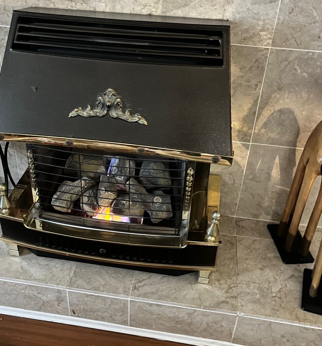 Another supplied view shows a hooded fireplace within a pale tiled surround. The setting is recorded as pictured; no location or work result is inferred